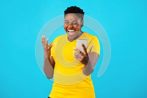 Joyful Black Woman Using Smartphone Posing Making Selfie, Blue Background