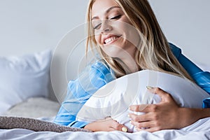 joyful blonde woman lying on pillow