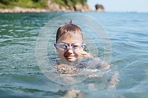 Joyful boy swims in the sea