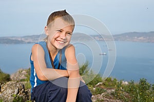 Joyful boy on top of a mountain