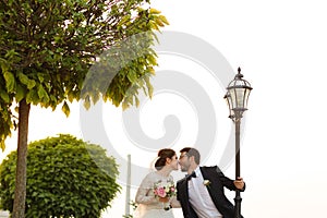 Joyful bride and groom with bouquet embracing