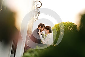 Joyful bride and groom with bouquet embracing