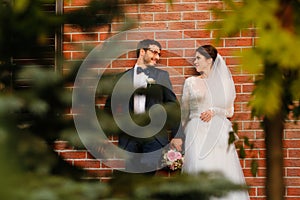 Joyful bride and groom with bouquet embracing