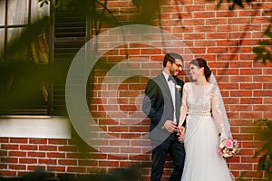 Joyful bride and groom with bouquet embracing