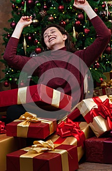 Joyful brunette woman overwhelmed with New Year gifts