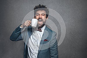 Joyful business man in suit with red bow tie and coffee
