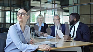 Joyful business woman dreaming during office meeting sitting at table, work