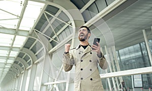 Joyful businessman dancing and talking phone about his new career