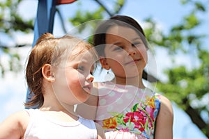 The joyful and carefree spirit of two little girls enjoying their time together on the playground during a sunny summer day