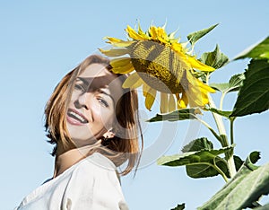 Joyful caucasian woman posing with yellow sunflower