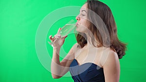 Joyful charming young woman drinking champagne from glass looking at camera smiling. portrait of positive confident