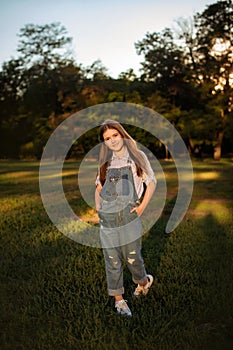 joyful child girl walking in summer park to meet with friends - childhood, leisure and people concept. vertical photo