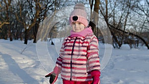 Joyful child kid running, having fun, dancing, fooling around on snowy road in winter park forest