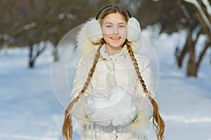 Joyful child playing in snow. happy girl having fun outside winter day