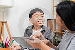 Interactive Learning and Engagement. A child happily interacting with a parent while using a tablet. photo