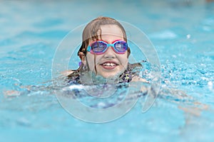 Joyful child in swimming pool in summer