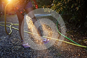 Joyful child watering in the golden hour, summer fun ensues