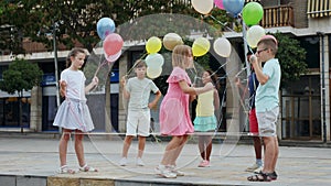 Joyful children playing with balloons and jumping rope outdoors.