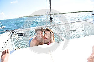 Joyful couple enjoying on catamaran