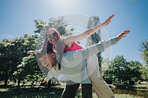 Joyful couple enjoying a piggyback ride in the park on a sunny day