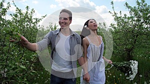 Joyful couple running hand in hand among trees