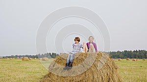 Joyful Couple Teens Jump Haystack Field Summertime