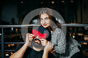 Joyful couple.Young woman covering her boyfriend`s eyes with red