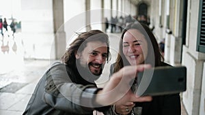 Joyful dating couple taking video selfie while drinking wine