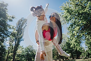 Joyful day at the park: Couple enjoying a piggyback ride surrounded by greenery