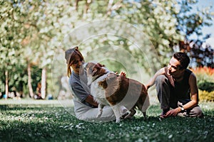 Joyful day in the park with a happy couple playing with their dog