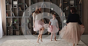 Joyful different generations family dancing in modern living room.