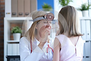 Joyful doctor examines the child nasopharynx portrait