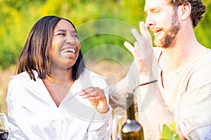 Joyful Duo: Mixed Race Couple Laughs Amidst Garden Party Festivities
