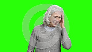 Joyful elderly lady is laughing on green screen.