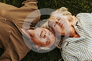 Joyful elderly twosome enjoying music outdoors with smile