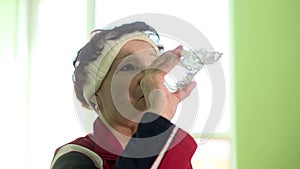 Joyful elderly woman having fitness training drinking water 4k