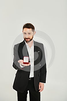 joyful elegant man showing jewelry box