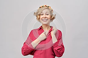 Joyful enthusiastic young girl with a big smile, in admiration, holding a hand to his chest.