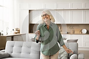 Joyful excited blonde senior woman in glasses enjoying motion