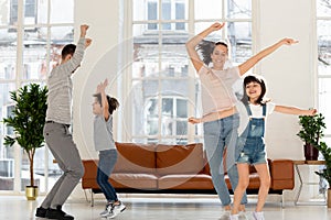 Joyful family enjoying dancing party in living room.