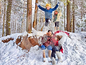 Joyful family ethnic dress with shawls and earflap hats in a winter forest in carnival Maslenitsa in Russia. Tourists in