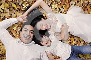 Joyful family lying on autumn park