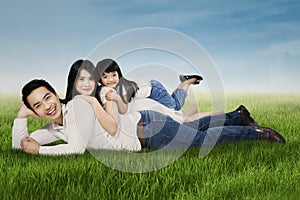 Joyful family lying on grass at the park