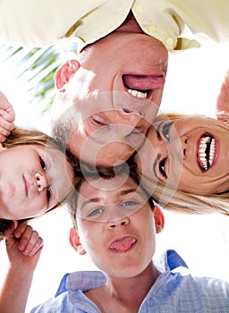 Joyful family making weird faces in huddle photo