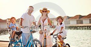 Joyful family riding bicycles along wooden promenade