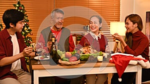 Joyful family talking and celebrating Christmas at dining table. Holidays and celebration concept