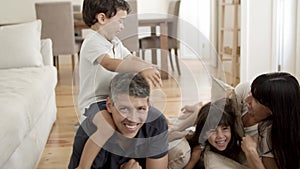 Joyful family with two kids relaxing at home