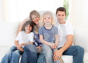 Joyful family watching television sitting on sofa