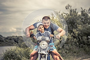 Joyful father biker son riding motorcycle lifestyle portrait concept happy paternity photo