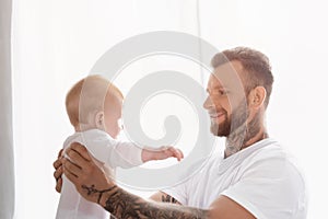 Joyful father holding infant son in